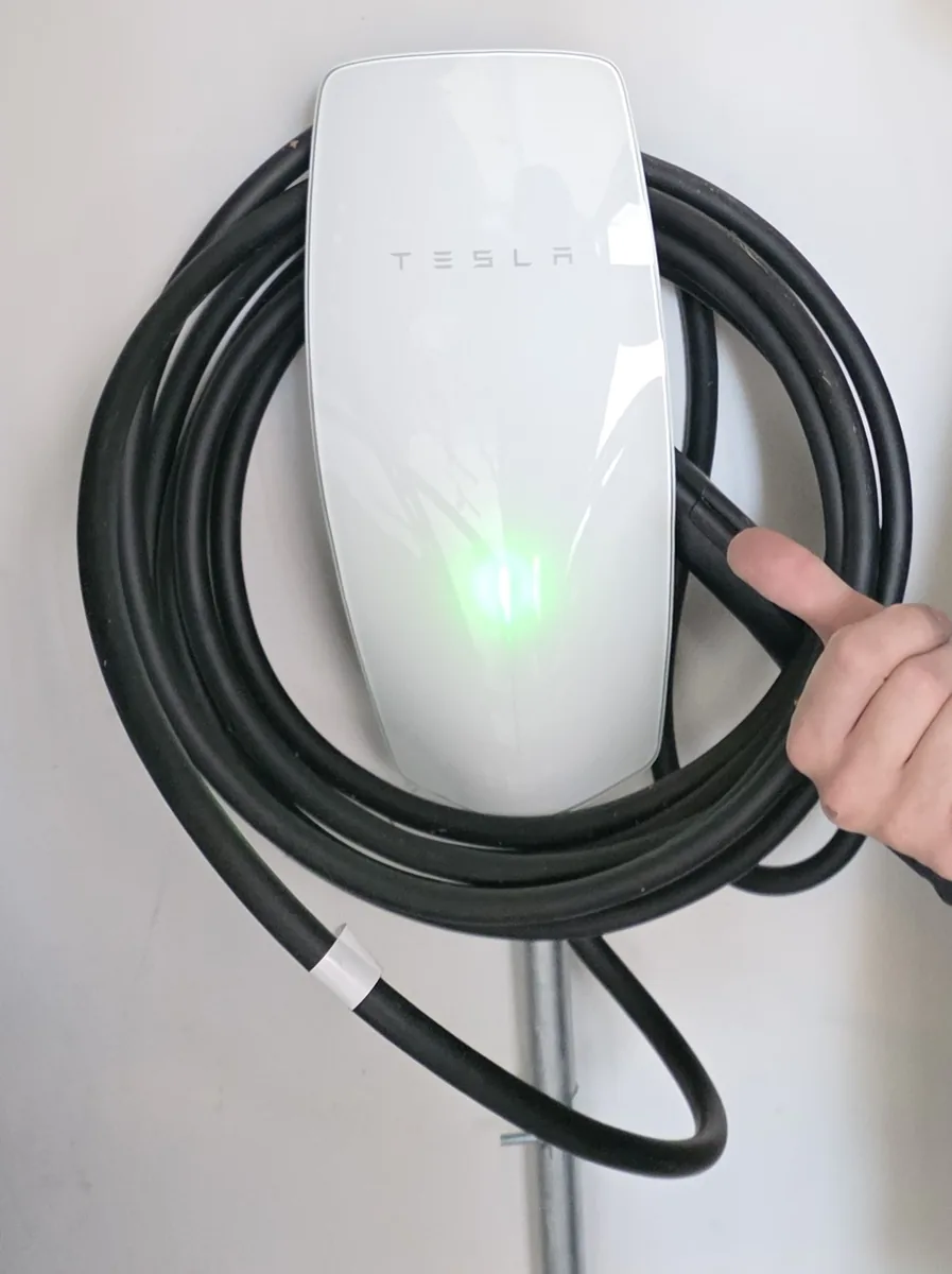 Hardwired Tesla Wall Connector fed by EMT conduit, powered up and ready to charge
