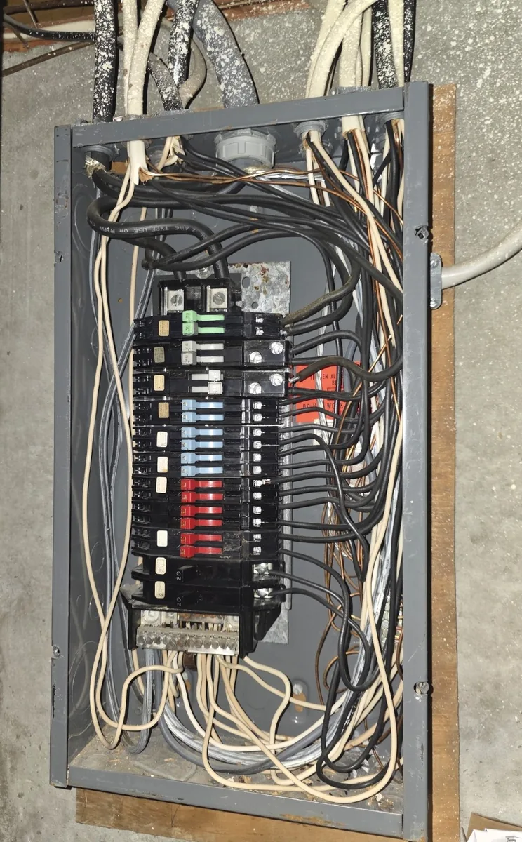A Zinsco panel still in service, colour-coded breaker handles visible with the cover off