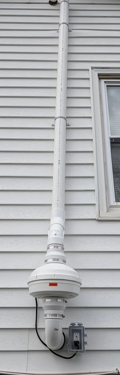 Radon fan mounted outside on the siding, wired to its own weatherproof outdoor receptacle